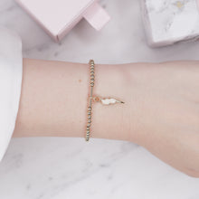 Load image into Gallery viewer, 14k gold filled beads 3mm gold filled bar lightning bolt champagne enamel 24k gold plated wire bracelet with tag and chain on wrist
