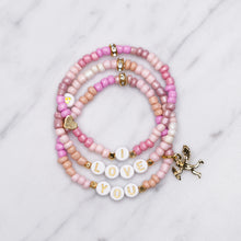 Load image into Gallery viewer, 24k gold plated painted bead elastic stretchy bracelets multicolour pink shades &#39;i love you&#39; cupid charm heart plastic gold heart rondelle 3 bracelets
