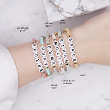 Load image into Gallery viewer, 24k gold plated elastic stretch bracelets names ethan phoebe molly esme rory grace evil eye enamel pink star 6 bracelets grey silver blue pink shimmer pearl sugar cookie biscuit blue grey on marble custom word personalised letters on wrist