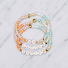 Load image into Gallery viewer, my little sister multicolour pastel stretch elastic bracelets orange pink champagne green mint white 24k gold plated star rondelle shimmer gold letter plastic beads on marble
