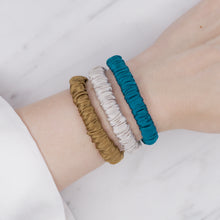 Load image into Gallery viewer, forest mud yellow mustard green turquoise grey warm silver trio three set mulberry silk soft hair tie hair band stretchy and kind to your hair on wrist