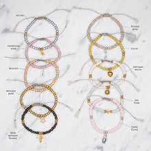 Load image into Gallery viewer, beaded tie up square knot nylon polyester cord grey pink blue cream white olive green metallic antique gold bronze silver tan charm bracelets with tassels friendship bracelets on marble labelled names