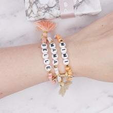 Load image into Gallery viewer, 24k gold plated painted bead elastic bracelets orange coral white shimmer pink enamel gold bee white cream tassel black heart accent feature bead plastic letter beads word personalised custom on wrist
