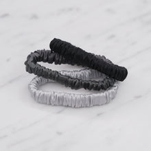 Load image into Gallery viewer, black dark grey monochrome ink grey cool silver trio three set mulberry silk soft hair tie hair band stretchy and kind to your hair on marble
