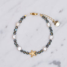 Load image into Gallery viewer, Smokey Crystal bicone Freshwater Pearl And 24K Gold Plated matte gold Starfish Bracelet on marble
