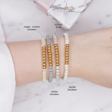 Load image into Gallery viewer, painted beaded elastic stretchy galvanised gold beads smokey grey matte pearl shimmer silver rondelle neutral stone 4 bracelets on wrist labelled colours
