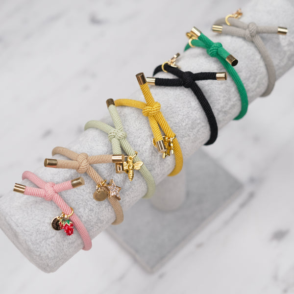 charm hair bands hair ties various colours unicorn star bee strawberry heart on jewellery stand display pink tan light green yellow mustard black grey on marble