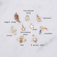 Load image into Gallery viewer, micro charms labelled cubic zirconia micro pave 24K gold plated cross bee star angel wing droplet initial rainbow on marble

